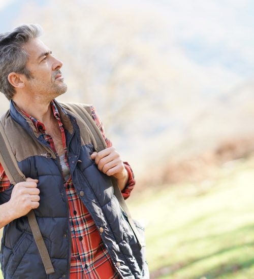 Hiker,With,Backpack,Walking,In,The,Mountain